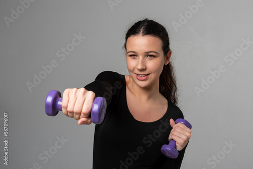 Young fitness model trains with dumbbells