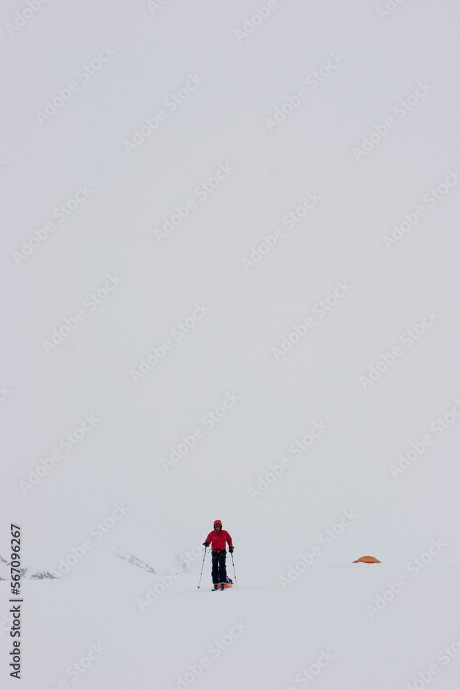 Glacier geology PhD student skis over the Brady Glacier during whiteout blizzard conditions, while pulling a sled of geophysical Glacier geology PhD student skis over the Brady Glacier during whiteout blizzard conditions, while pulling a sled of geophysical