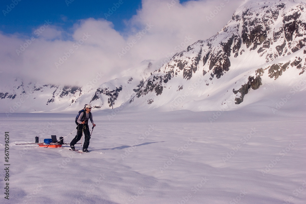 Glacier geology PhD student skis over the Brady Glacier, while pulling a sled of geophysical equipment. Glacier geology PhD student skis over the Brady Glacier, while pulling a sled of geophysical equipment.