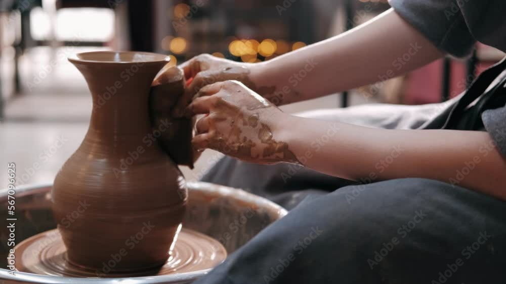 Female potter make clay pot on the pottery wheel. Close up shot of potter making ceramic pot on pottery wheel at workshop, slow motion. Creativity and traditional crafts concept. Female potter make clay pot on the pottery wheel. Close up shot of potter making ceramic pot on pottery wheel at workshop, slow motion. Creativity and traditional crafts concept.