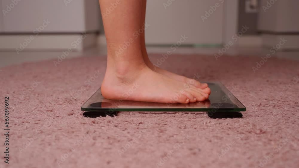 Girls legs on the scales close-up. Young female person measure body