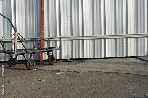 A cart markets stay beside a galvanized fence.