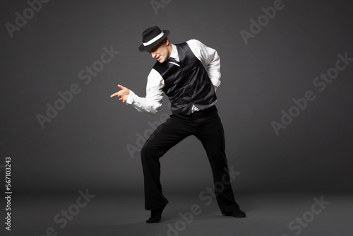 Confident young man dancing in gangster style suite.