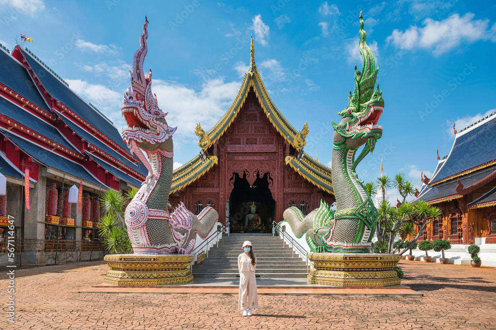 Asian female tourist come to worship at Wat Ban Den or Wat Den Salee Sri Muang Gan the Lanna style temple and colorful statue sculpture at Chiang Mai Asian female tourist come to worship at Wat Ban Den or Wat Den Salee Sri Muang Gan the Lanna style temple and colorful statue sculpture at Chiang Mai