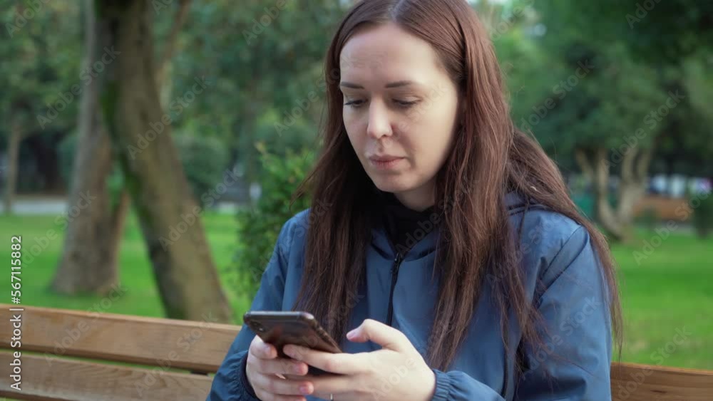 Young student freelancer woman in park sitting on bench, drinking coffee outdoor and using mobile cell phone smiling. Modern urban people lifestyle. Young student freelancer woman in park sitting on bench, drinking coffee outdoor and using mobile cell phone smiling. Modern urban people lifestyle.