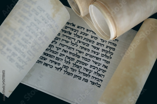 Open Megillat Esther (Book of Esther) isolated scroll on black backround. Read on the Jewish holiday of Purim. photo