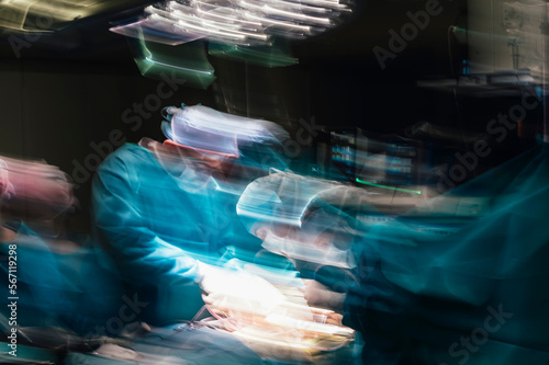 Bild auf Leinwand Motion photography with slow exposure of the doctor with mask doing a surgery