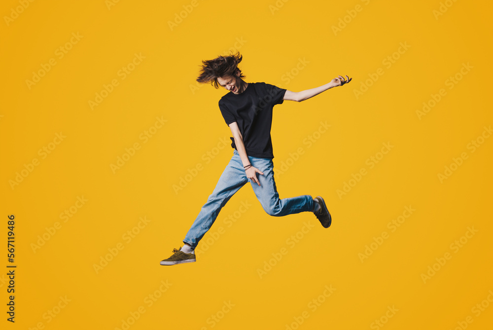 Full length photo of young handsome man jumping high up rejoicing celebrating success isolated yellow color background