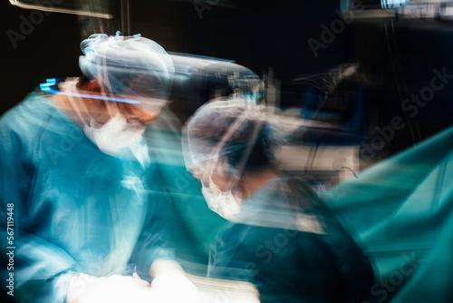 Bild auf Leinwand Motion photography with slow exposure of the doctor with mask doing a surgery