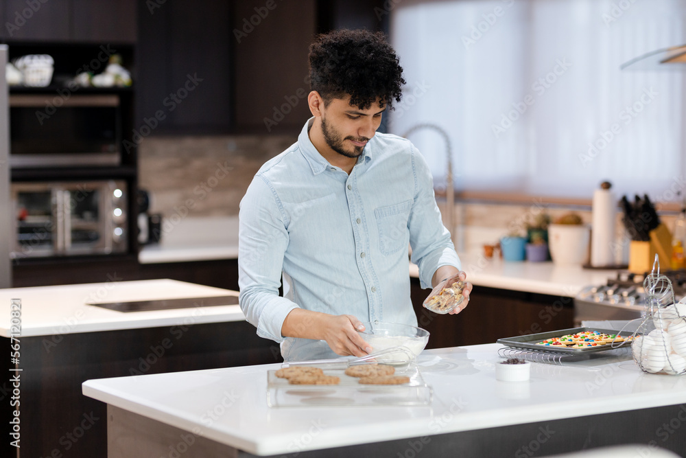 Fototapeta premium Hispanic man preparing desserts in the kitchen of his house - Happy young man cooking - Pastry man