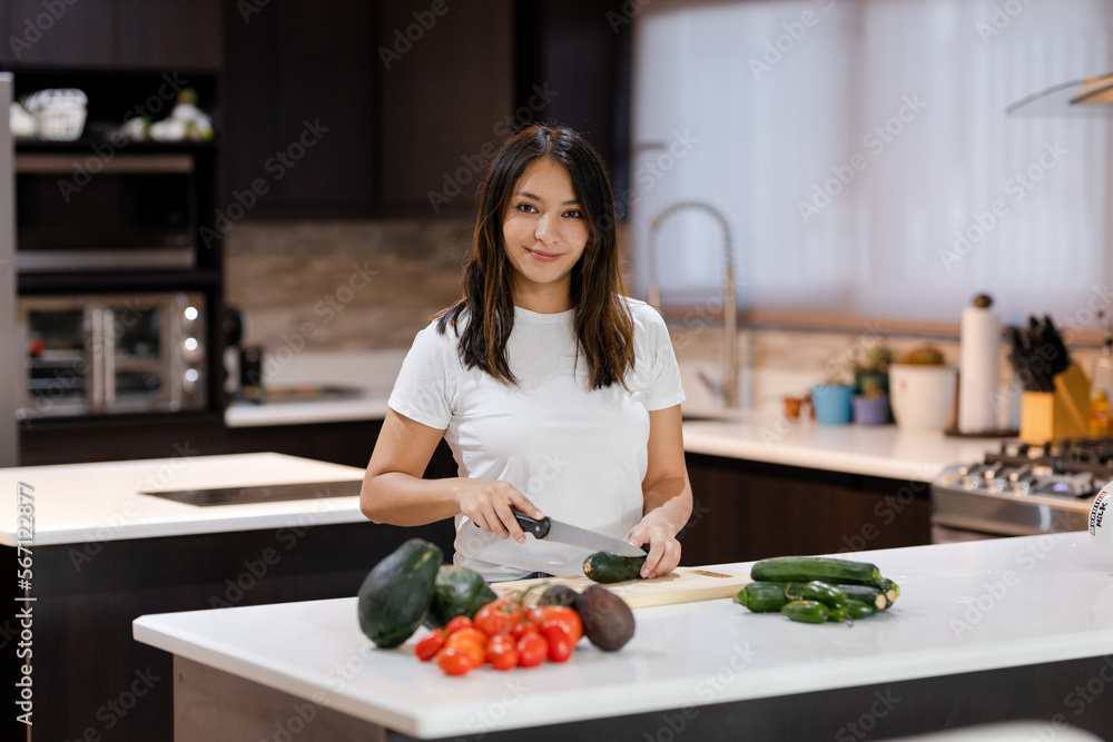 Hispanic woman cooking healthy salad in her kitchen - Young housewife making healthy recipes Hispanic woman cooking healthy salad in her kitchen - Young housewife making healthy recipes