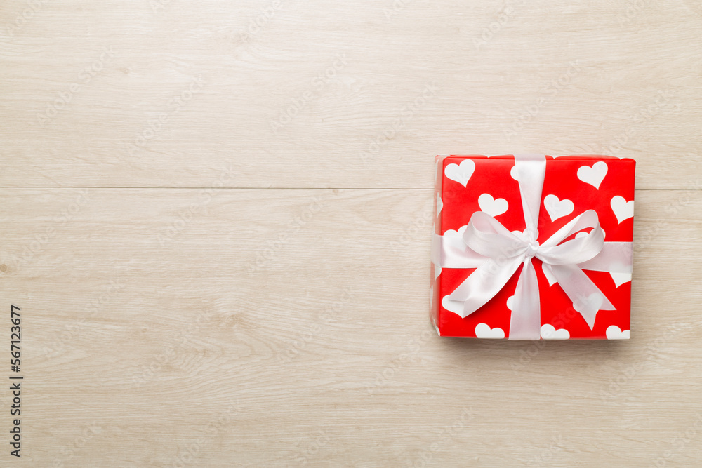 Gift box with hearts on wooden background, top view Gift box with hearts on wooden background, top view