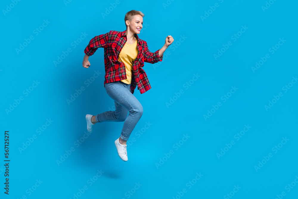 Fototapeta premium Full body length photo of youngster funky girl running jumping hurry wear stylish casual outfit clothes brand isolated on blue color background