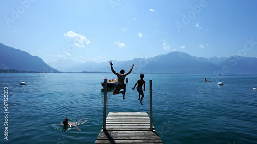 Leinwand Poster People jumping into lake water