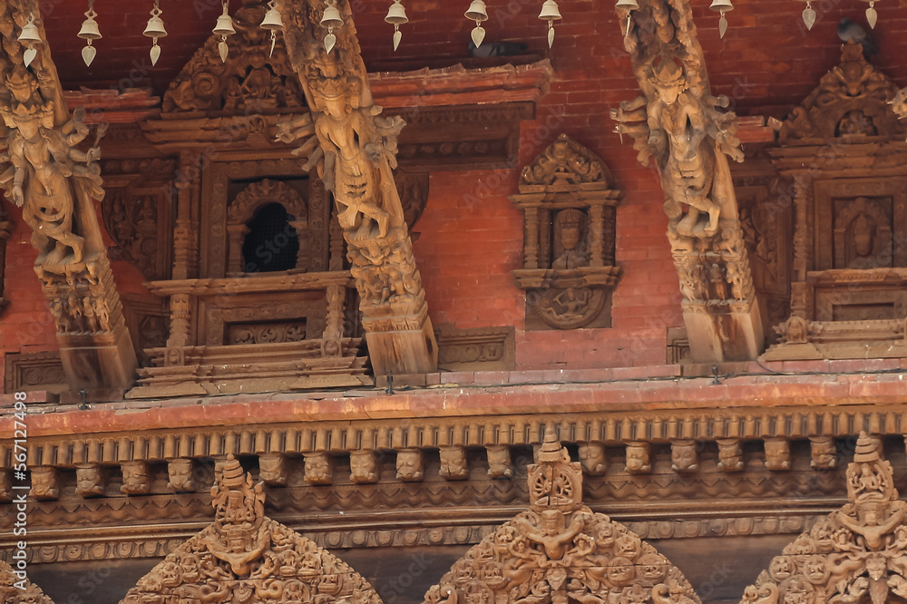 Carved wooden hindu and buddhist gods and tympanums on Vishwanath temple on Patan Durbar Square in Lalitpur, Nepal. Selective focus. Religious architecture theme.