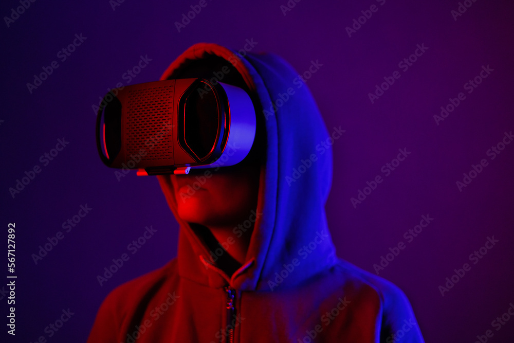 Obraz premium person wearing virtual reality glasses gets experience of gaming and entertainment. people in VR touches space with hands, blue and red light of abstract lamps. modern technologies of future