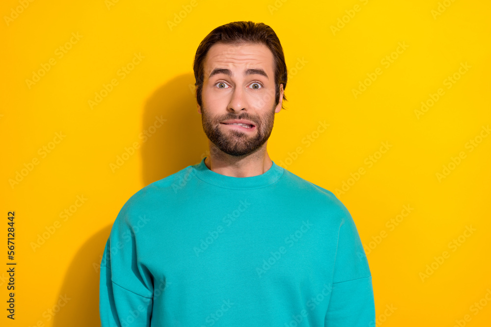 Photo of young funny attractive stressed nervous student man bristle beard bite lips wear blue sweatshirt debt isolated on yellow color background Photo of young funny attractive stressed nervous student man bristle beard bite lips wear blue sweatshirt debt isolated on yellow color background