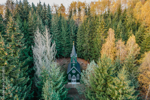 Aerial view of wooden rural chapel called Tichackova kaple in Broumovsko region,Czech republic.Catholic church in autumn countryside.Religious meditation scenery.Pilgrimage place with person in forest