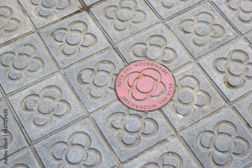 Sidewalk with panot (tiles with flower inside) and the red Ruta Modernista panot in Barcelona, Catalonia, Spain, Europe Sidewalk with panot (tiles with flower inside) and the red Ruta Modernista panot in Barcelona, Catalonia, Spain, Europe