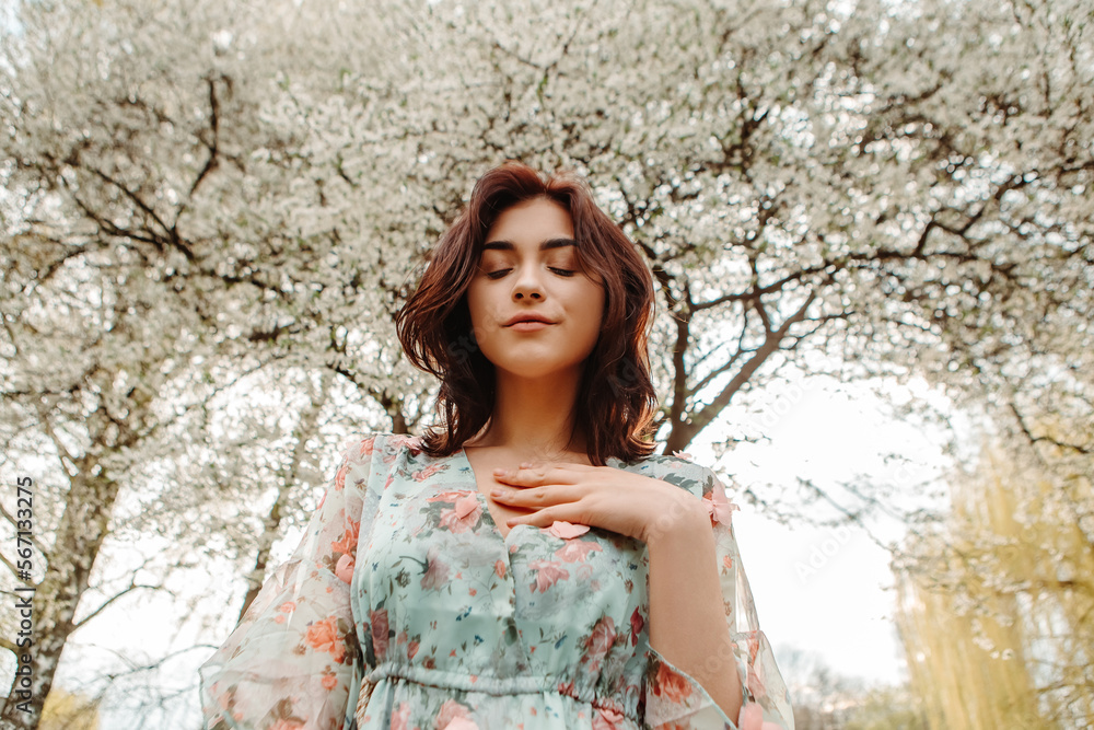 Bottom view of charming pretty woman dressed flowery dress posing near apple cherry tree blossoms blooming flowers in the garden park in early spring nature. Fashion, girl model with black hair
Bottom view of charming pretty woman dressed flowery dress posing near apple cherry tree blossoms blooming flowers in the garden park in early spring nature. Fashion, girl model with black hair