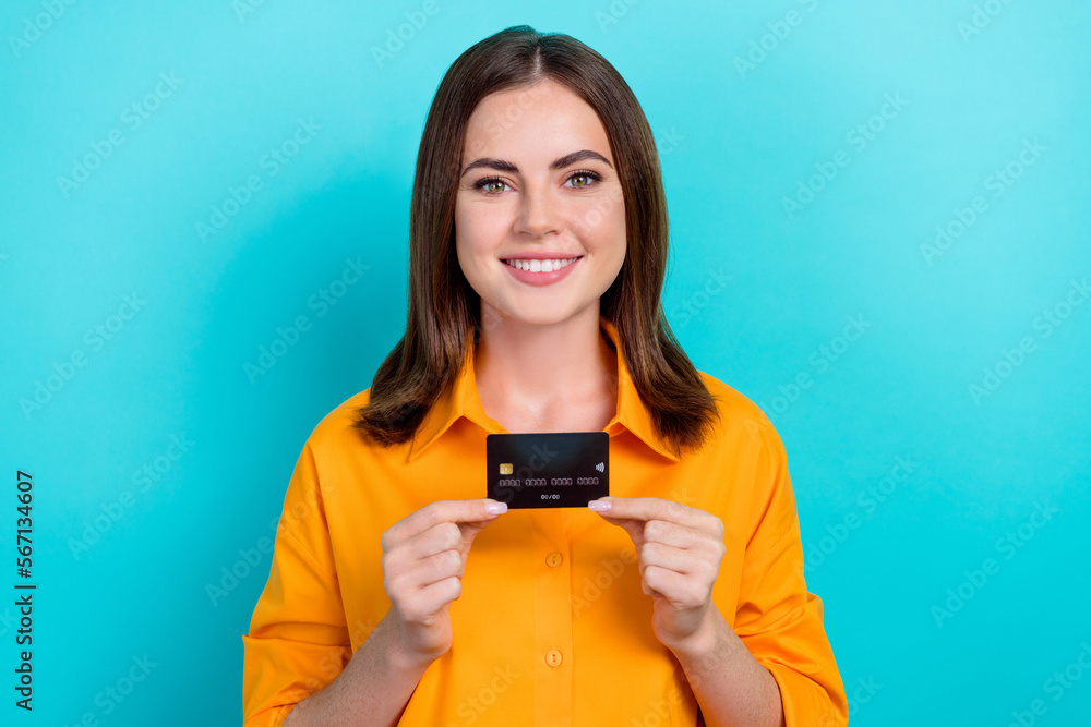 Portrait of adorable optimistic girl with bob hairstyle dressed yellow shirt fingers hold plastic card isolated on blue color background Portrait of adorable optimistic girl with bob hairstyle dressed yellow shirt fingers hold plastic card isolated on blue color background
