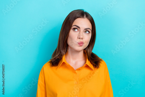 Photo of adorable gorgeous woman with straight hairdo wear yellow shirt look empty space choose shop isolated on blue color background