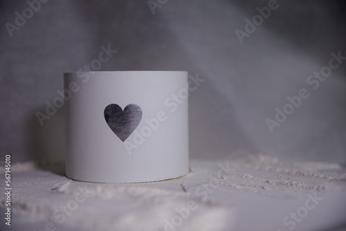 Valentine’s Day. Silver heart on white box. Festive round box. Minimalist print gift box. Texture picture