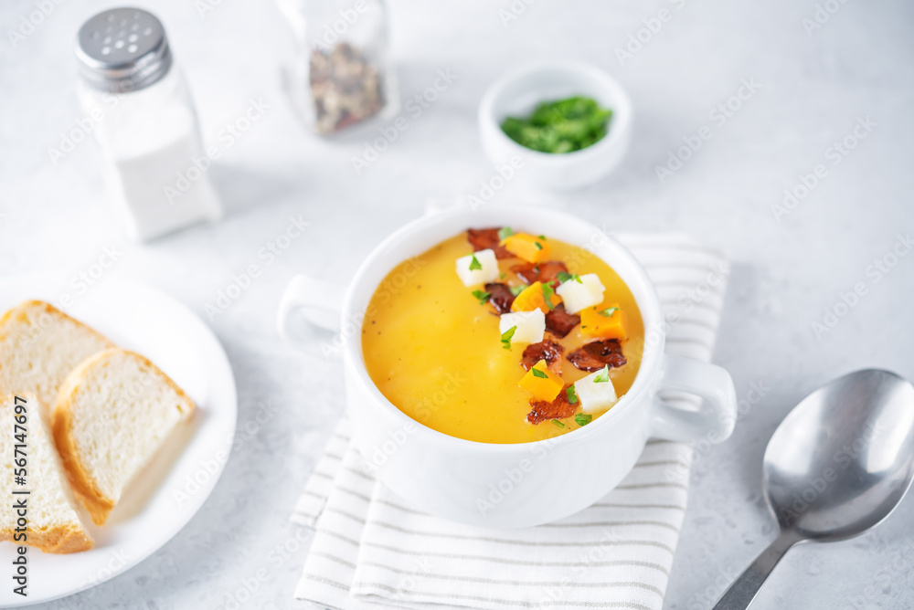 Potato carrot soup with fried bacon slices in a bowl Potato carrot soup with fried bacon slices in a bowl