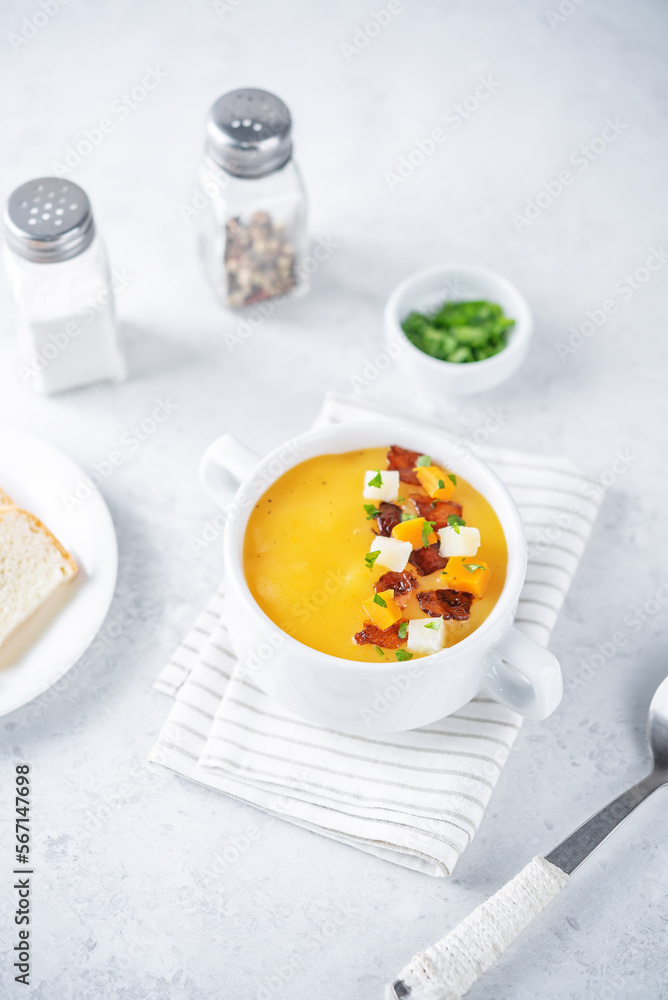 Potato carrot soup with fried bacon slices in a bowl Potato carrot soup with fried bacon slices in a bowl