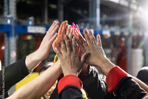 Multiracial happy people stacking hands.