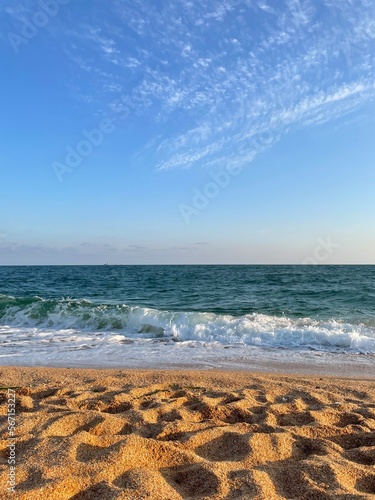 Golden beach with turquoise waves of the sea.