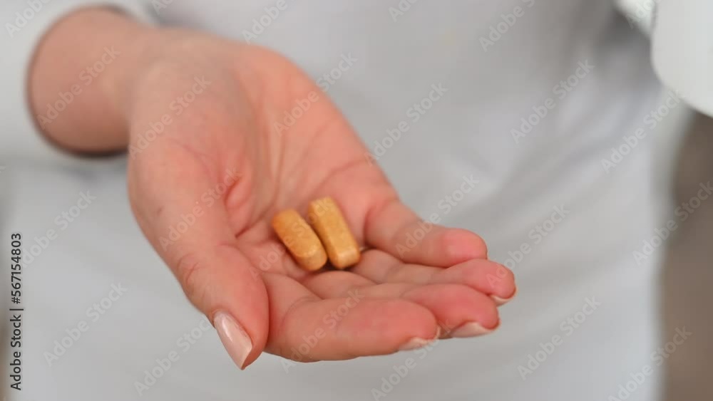 Woman at home taking vitamin pills Woman at home taking vitamin pills