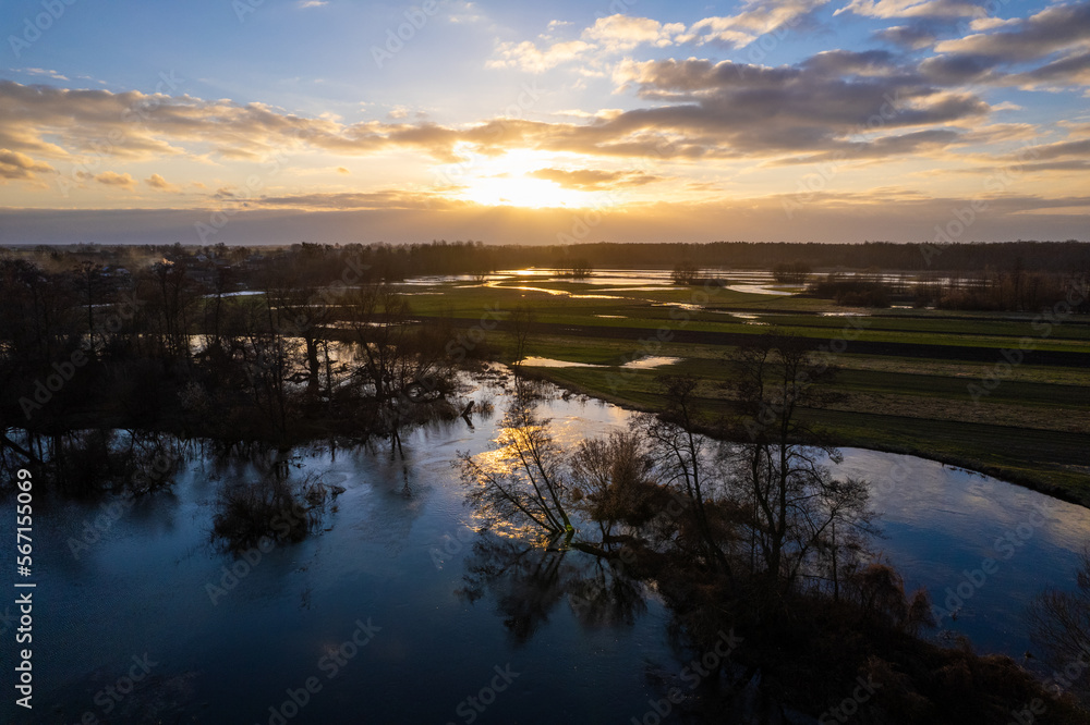 Sunset over flooded fields. Sunset reflection in submerged fields. Submerged fields. Afternoon sun reflection in submerged fields.