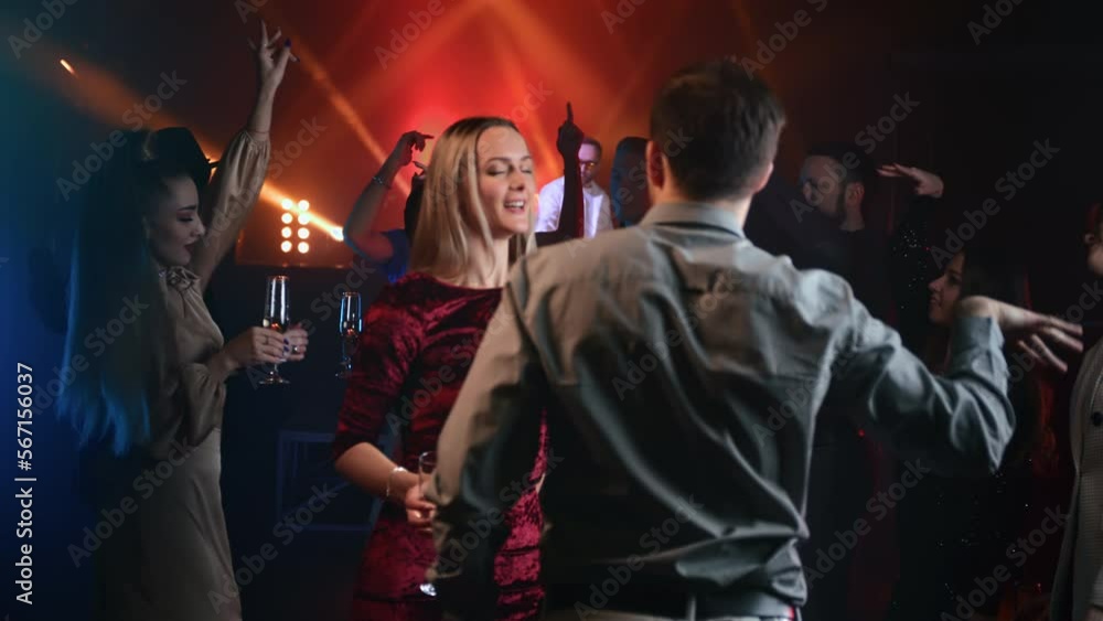 Happy man and woman crowded audience dancing at nightclub party drinking champagne alcohol Happy man and woman crowded audience dancing at nightclub party drinking champagne alcohol