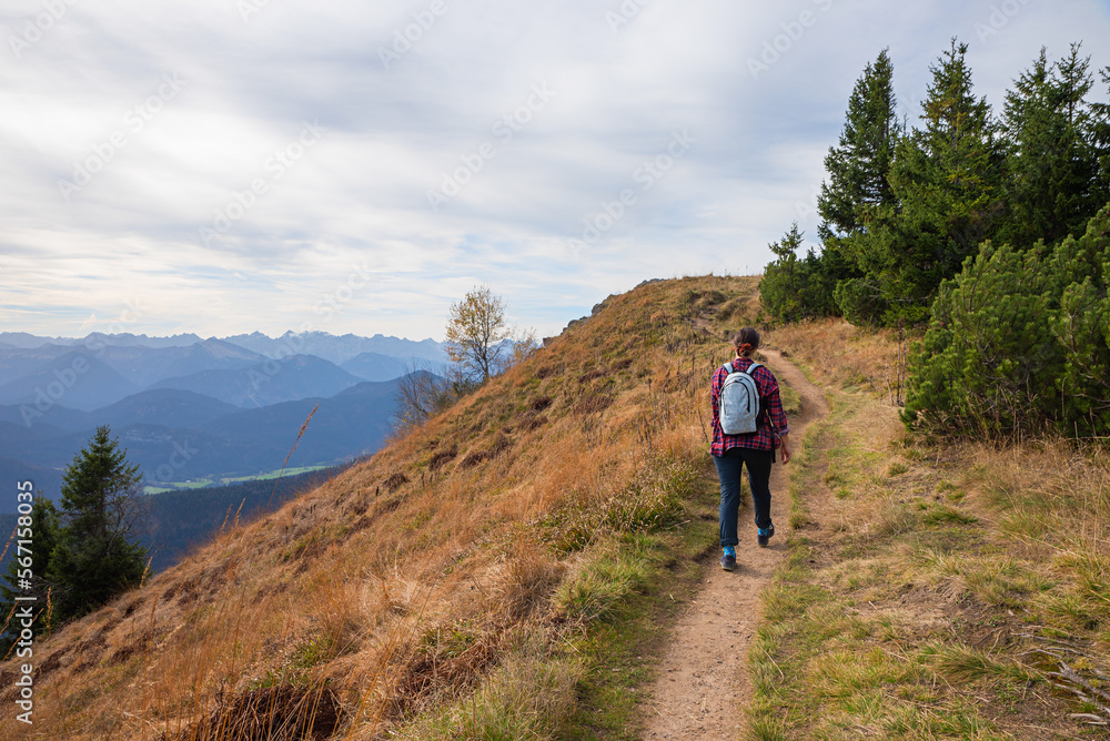 young woman hiking at mountain ridgeway Brauneck, Bavarian alps