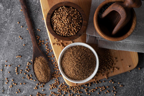 Coriander grains and coriander powder in a wooden bowl. Coriander seeds. Coriander spice. © Annmellsun