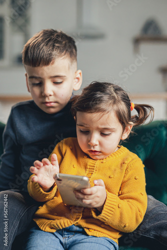 Brother and sister using technology at home