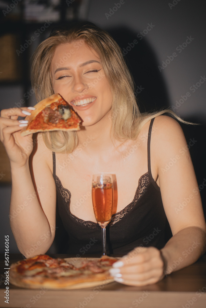 Piękna Kobieta Blondynka jedząca Pizzę z napojem drinkiem w ręce. - obrazy, fototapety, plakaty 
