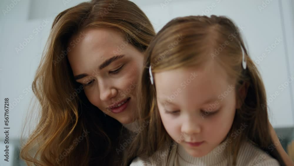 Little girl cooking with tender woman kitchen portrait. Mother embracing child Little girl cooking with tender woman kitchen portrait. Mother embracing child