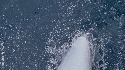 The bow of the yacht cuts the surface of the sea in foam and spray. A beautiful close-up shot from above of the prow of a yacht slicing through the waves. The concept of sea travel on a yacht.