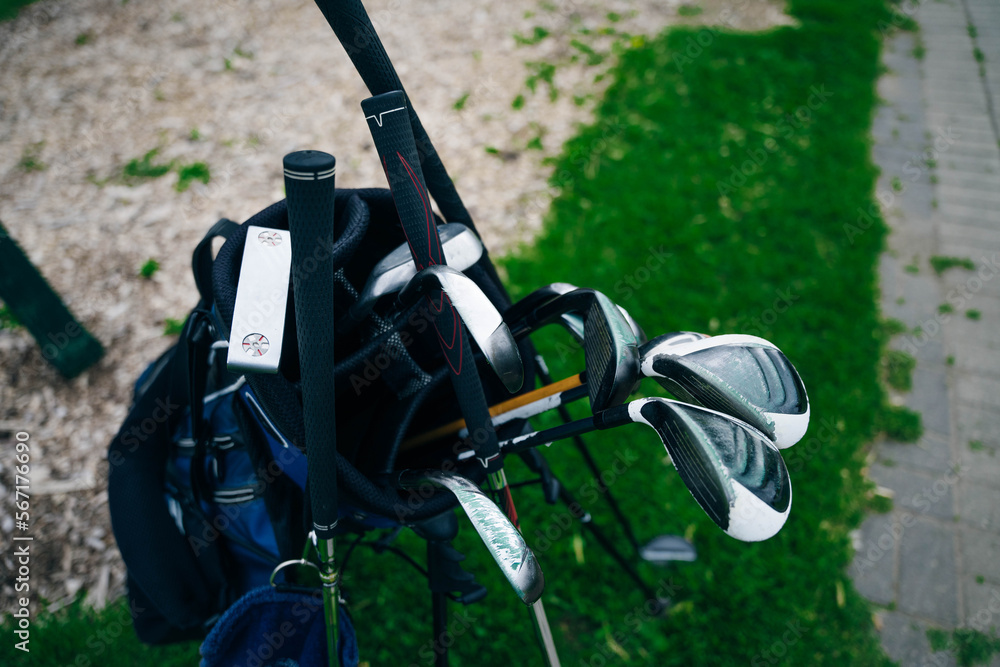 Golf ball and golf club in bag on green grass Golf ball and golf club in bag on green grass