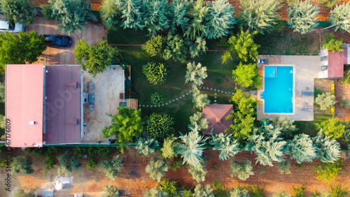Title: blue swimming pool. The pool with people swimming in it, taken from the hill. people swimming in the pool