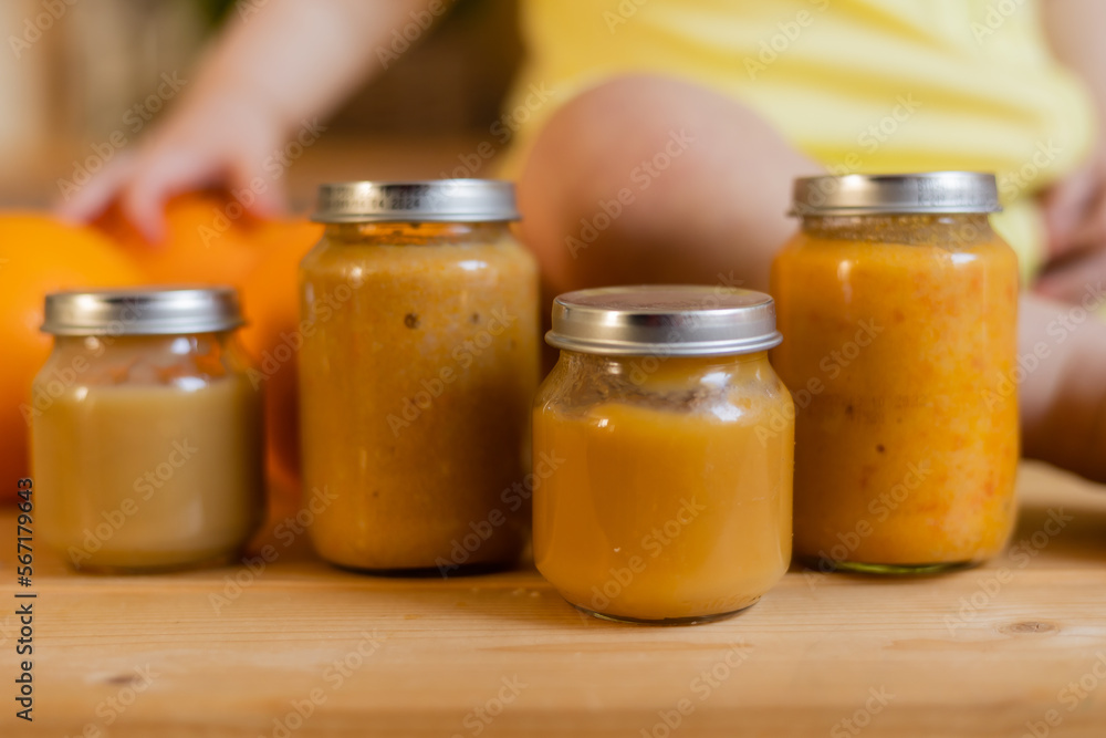 baby vegetable and fruit puree in jars in the kitchen, mockup. Baby food, space for text. Jars of baby food on a wooden table baby vegetable and fruit puree in jars in the kitchen, mockup. Baby food, space for text. Jars of baby food on a wooden table