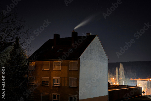 house in the cold night with smoking chimney 
