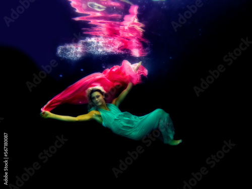 Model underwater with long dress and chiffon in pool