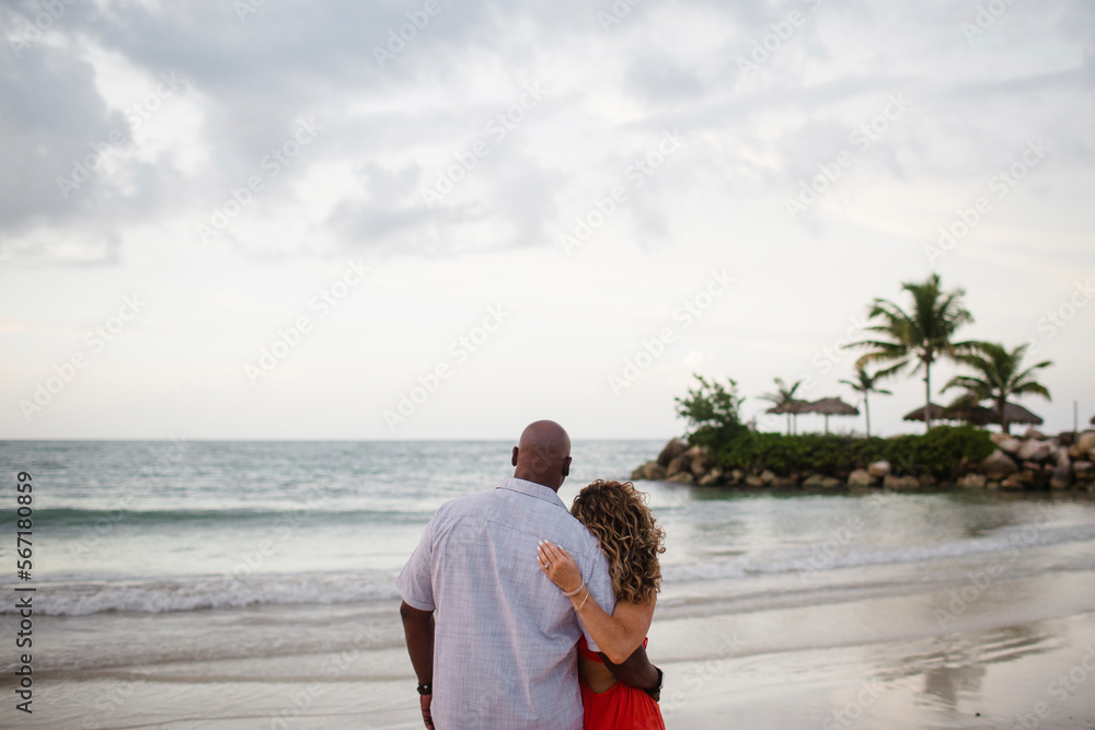 Rear view of couple standing at beach Rear view of couple standing at beach