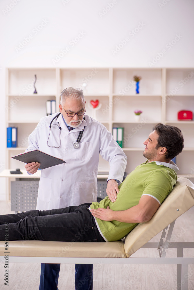 Fototapeta premium Young male patient visiting old male doctor