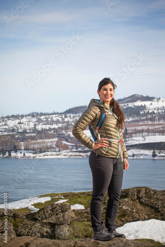 Portrait of young woman posing against river and snowy hill, Bingen, Washington, USA photo