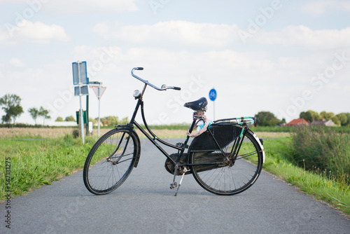 Vintage black typically Dutch bicycle with worn leather seat is propping up on bike path, Groningen, Netherlands photo