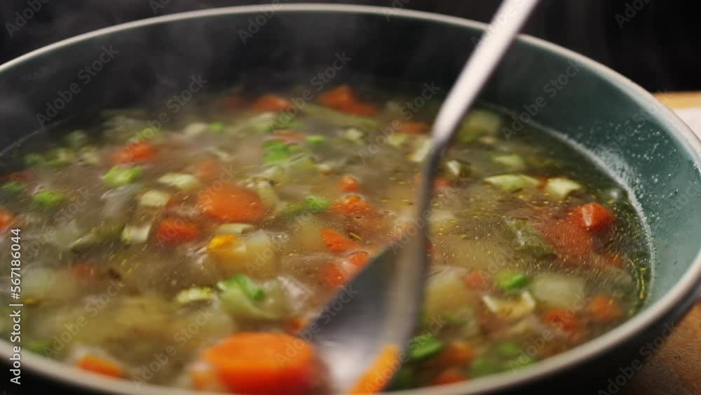 Homemade chicken vegetable soup cooking, close up view of chef cooking vegan healthy soup in big pan pot. Homemade chicken vegetable soup cooking, close up view of chef cooking vegan healthy soup in big pan pot.